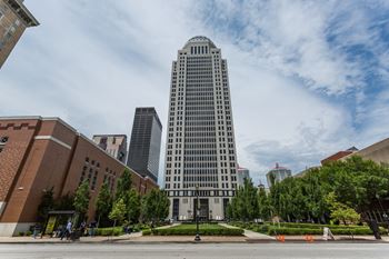 a tall skyscraper in a city with a park in front of it at 310 at Nulu Apartments-Student, Louisville, KY 40202